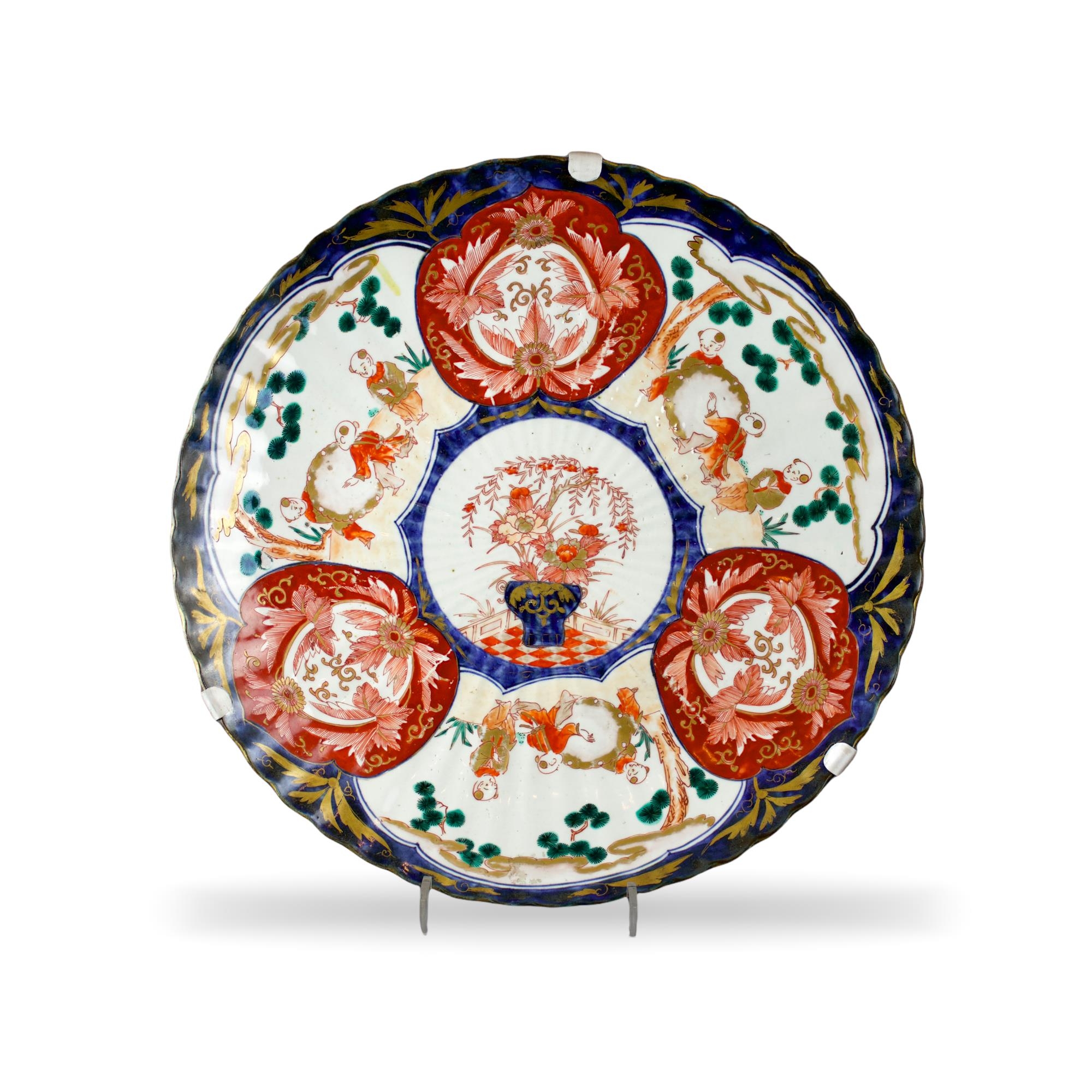 A Japanese Imari Fluted Dish, c. 1900 - - W45.5cm H5.5cm - - the shallow well with three vignettes
