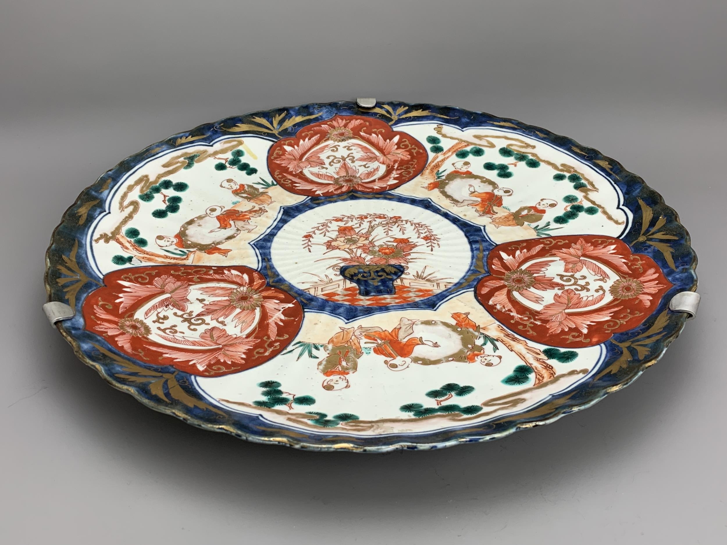 A Japanese Imari Fluted Dish, c. 1900 - - W45.5cm H5.5cm - - the shallow well with three vignettes - Image 2 of 5