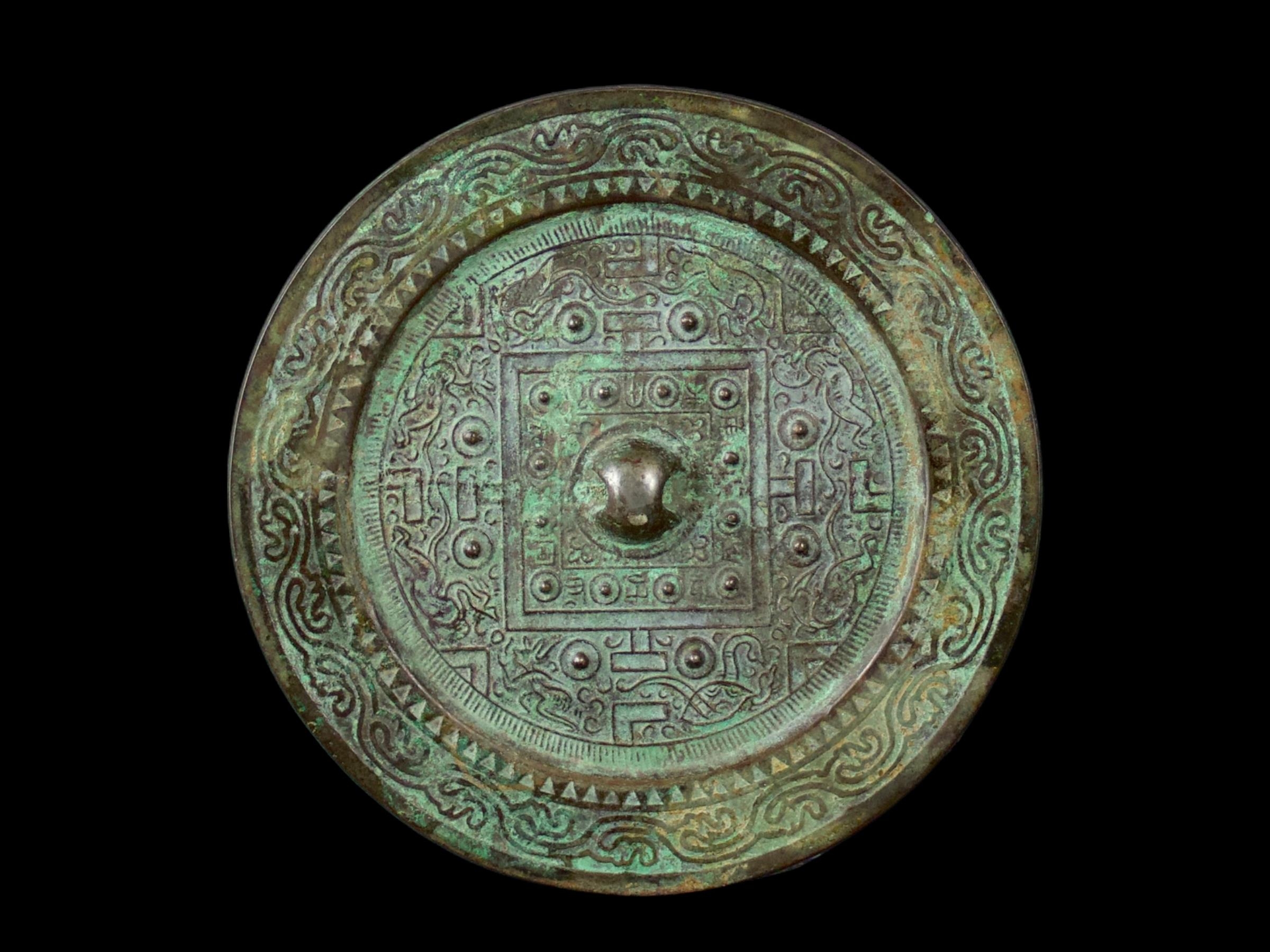An Archaic Bronze 'TLV' Mirror, Han Dynasty - - H1cm W13.5cm - - the raised central knob enclosed