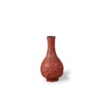 A well carved cinnabar bottle vase, carved with a continuous scene of figures in gardens,