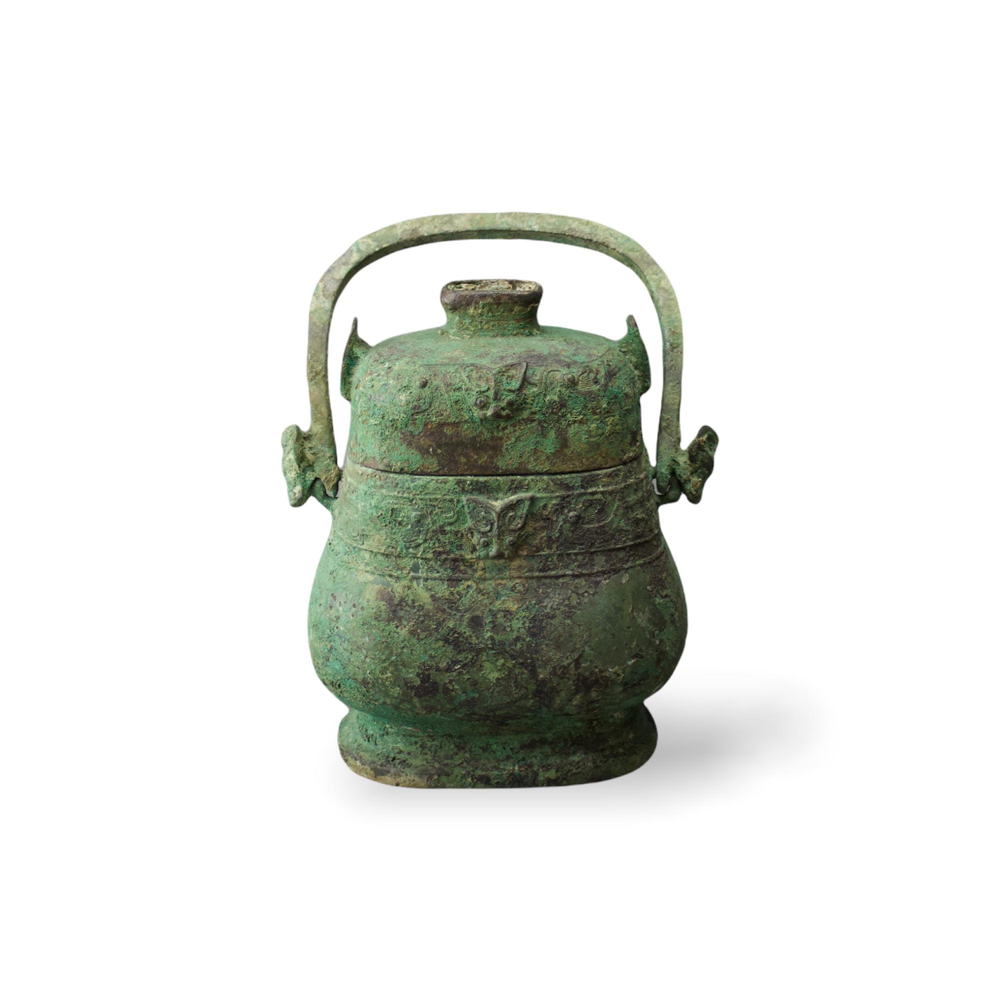 A bronze you and cover, the swing handle with horned beast head terminals, early Western Zhou