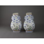 A pair of 'famille rose' vases, of hu form and rectangular section, Qianlong Mark - - H21.5cm