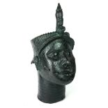 A 20TH CENTURY BENIN BRONZE HEAD, wearing a ceremonial headdress and engraved reeded design to face.
