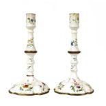 A pair of Battersea enamel candlesticks