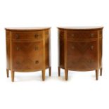 A pair of walnut demilune three drawer commodes,