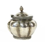 An oval, lobed, silver tea caddy