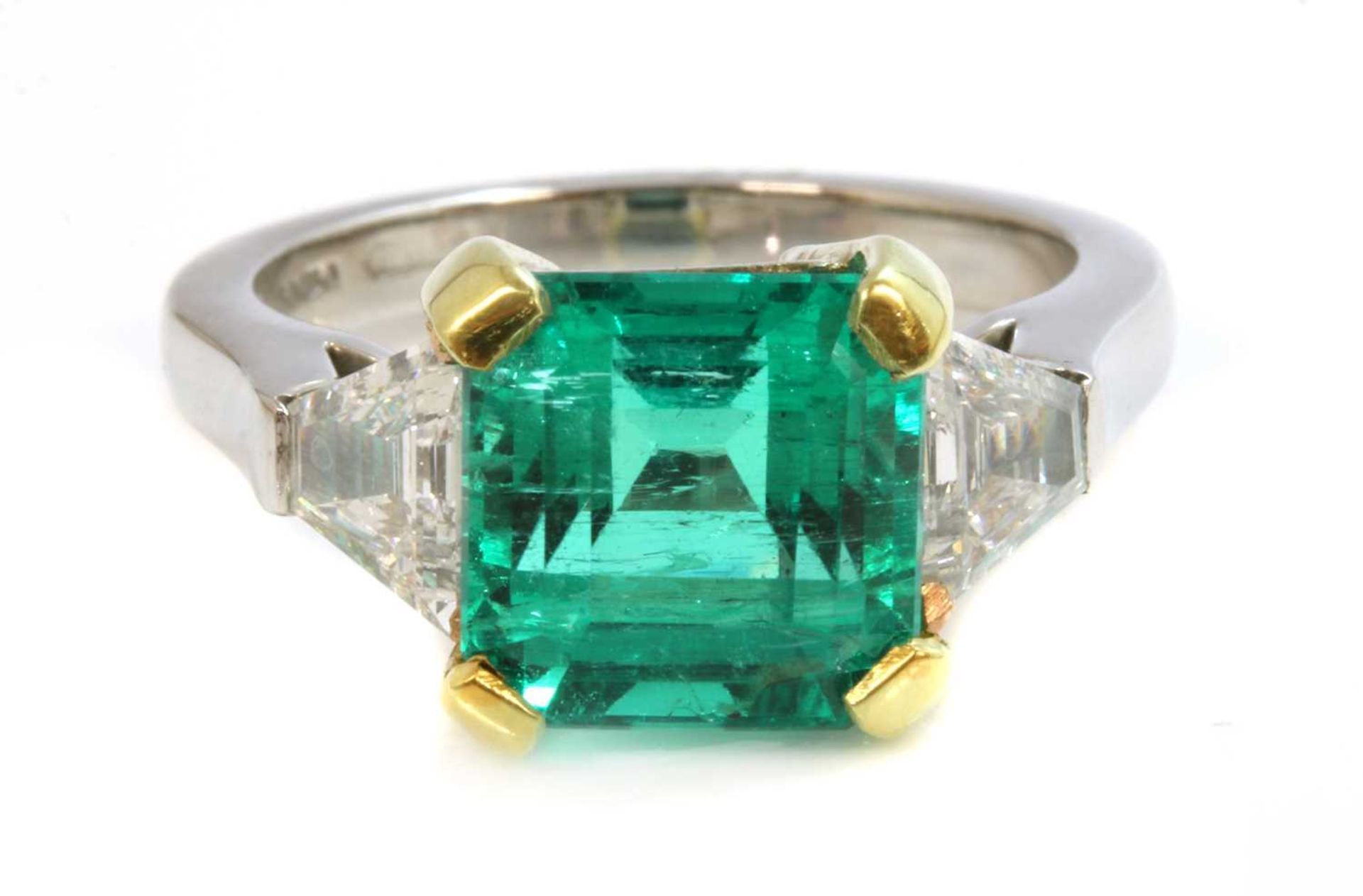 A platinum and gold Colombian emerald and diamond three stone ring,