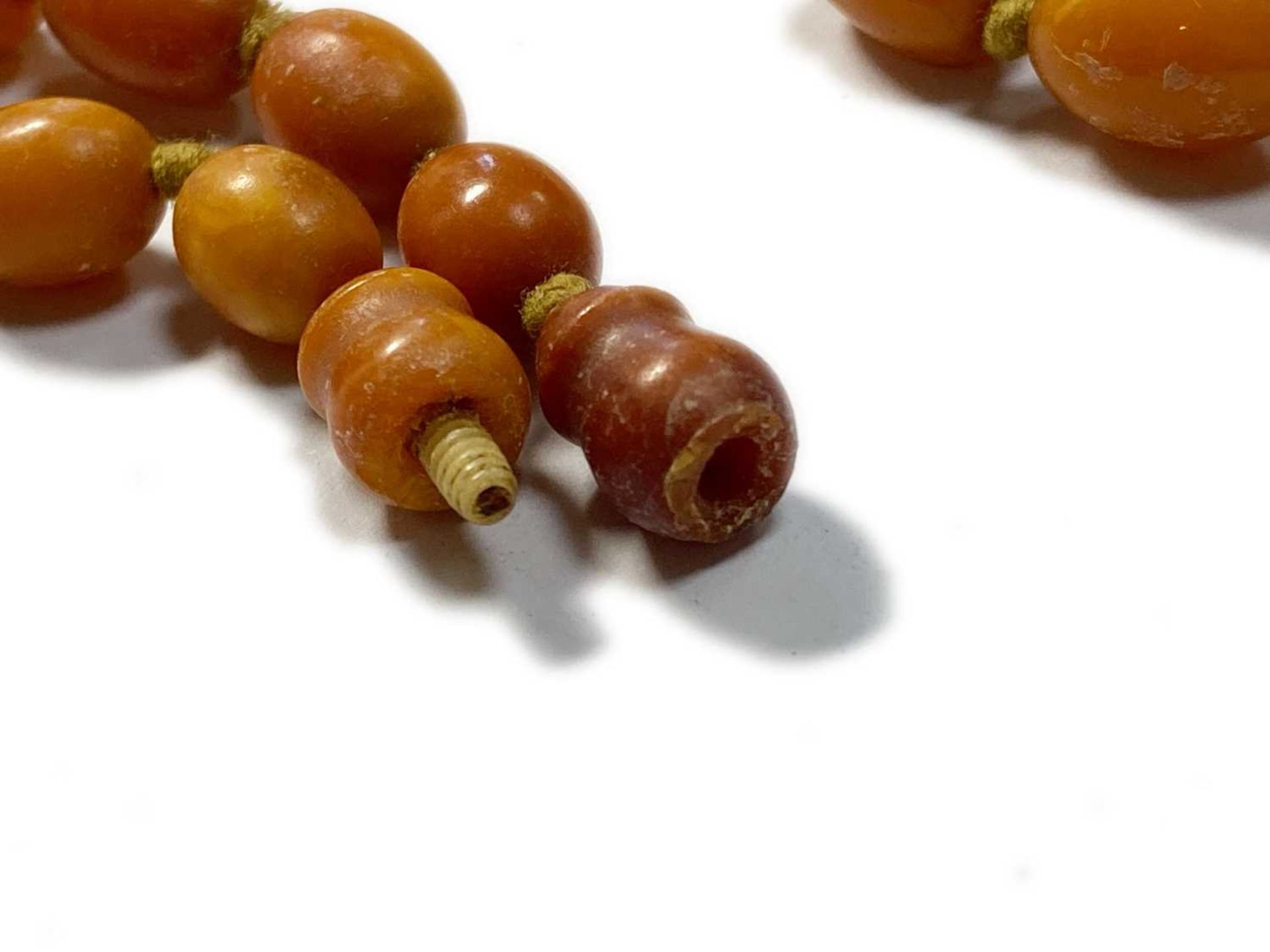 A single row graduated olive-shaped butterscotch amber bead necklace, - Image 7 of 12