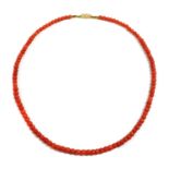 A single row graduated faceted coral bead necklace,