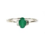 A white gold emerald and diamond three stone ring,