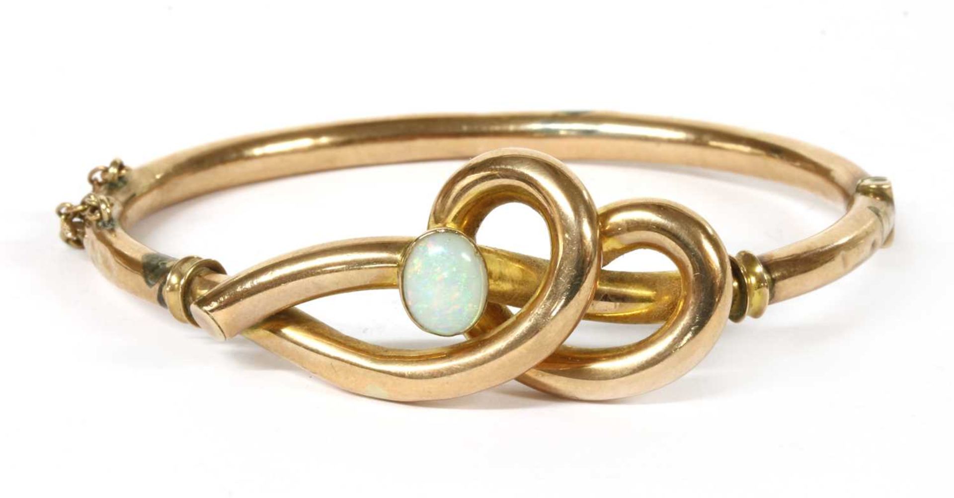 A gold opal set hollow hinged bangle,