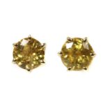A pair of gold single stone yellow sapphire stud earrings,