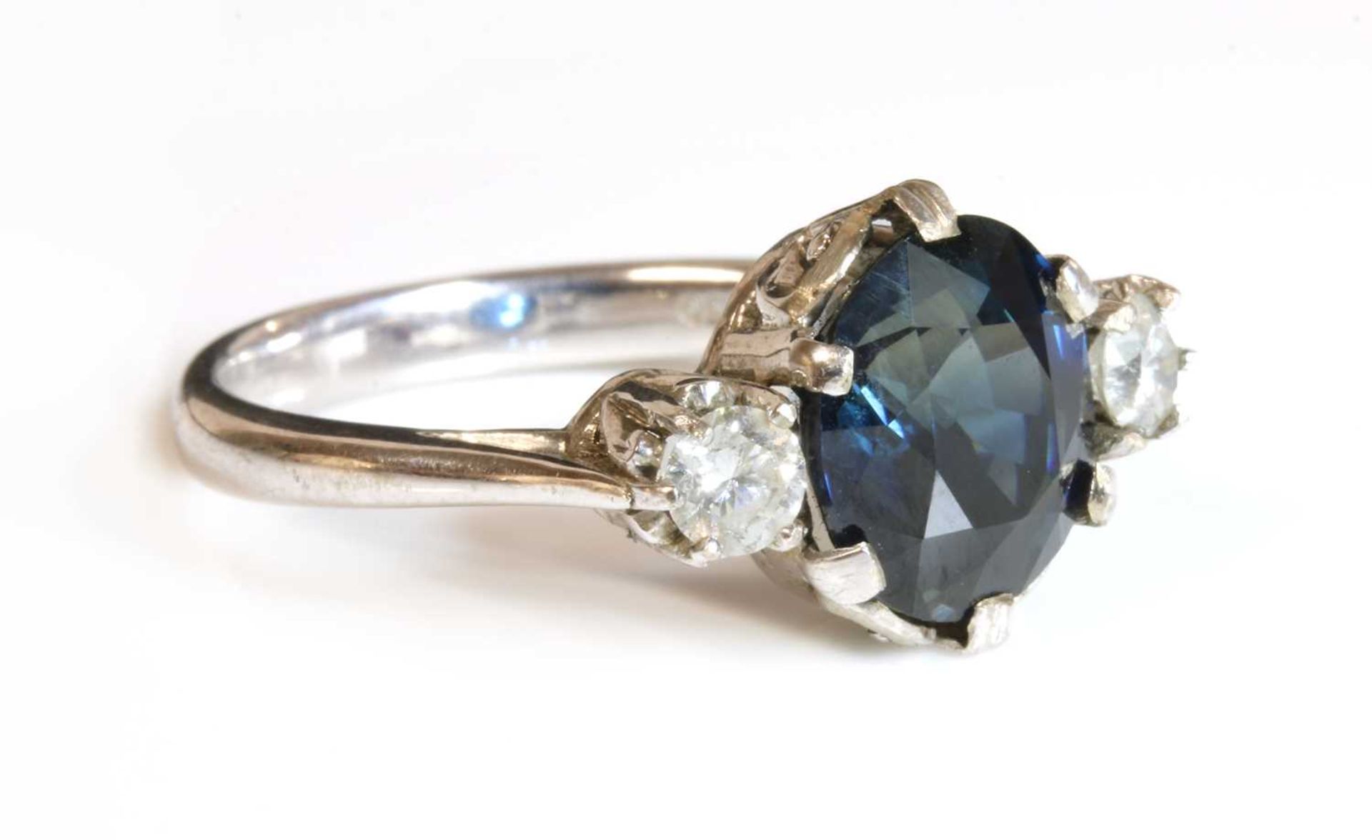 An 18ct white gold sapphire and diamond three stone ring,