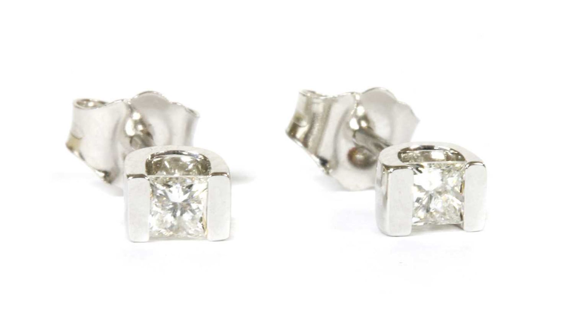 A pair of white gold single stone diamond stud earrings,