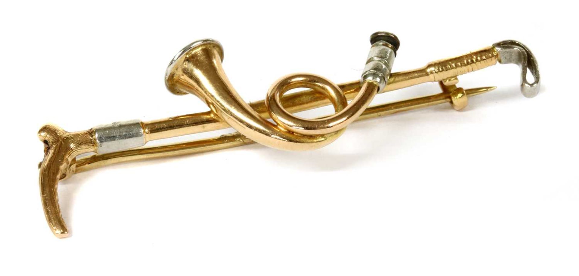 A gold and platinum hunting horn brooch,