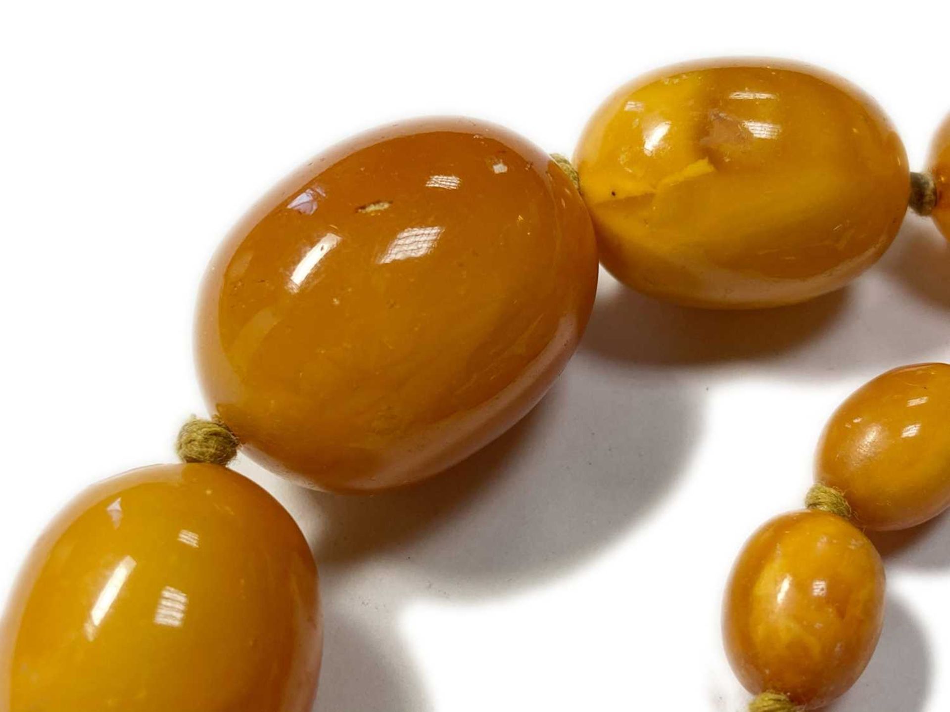 A single row graduated olive-shaped butterscotch amber bead necklace, - Image 10 of 12