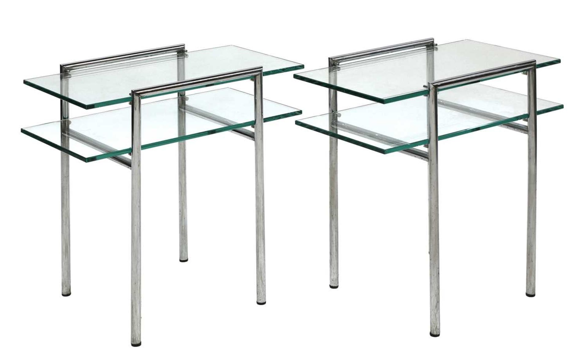 A pair of chrome and glass side tables,