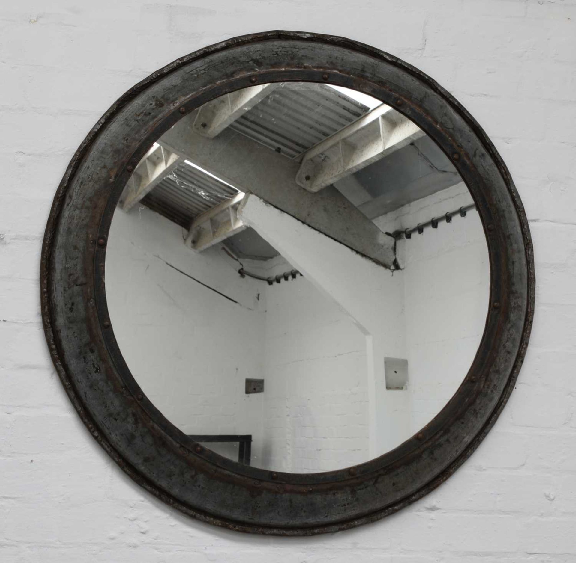 An industrial metal circular mirror,