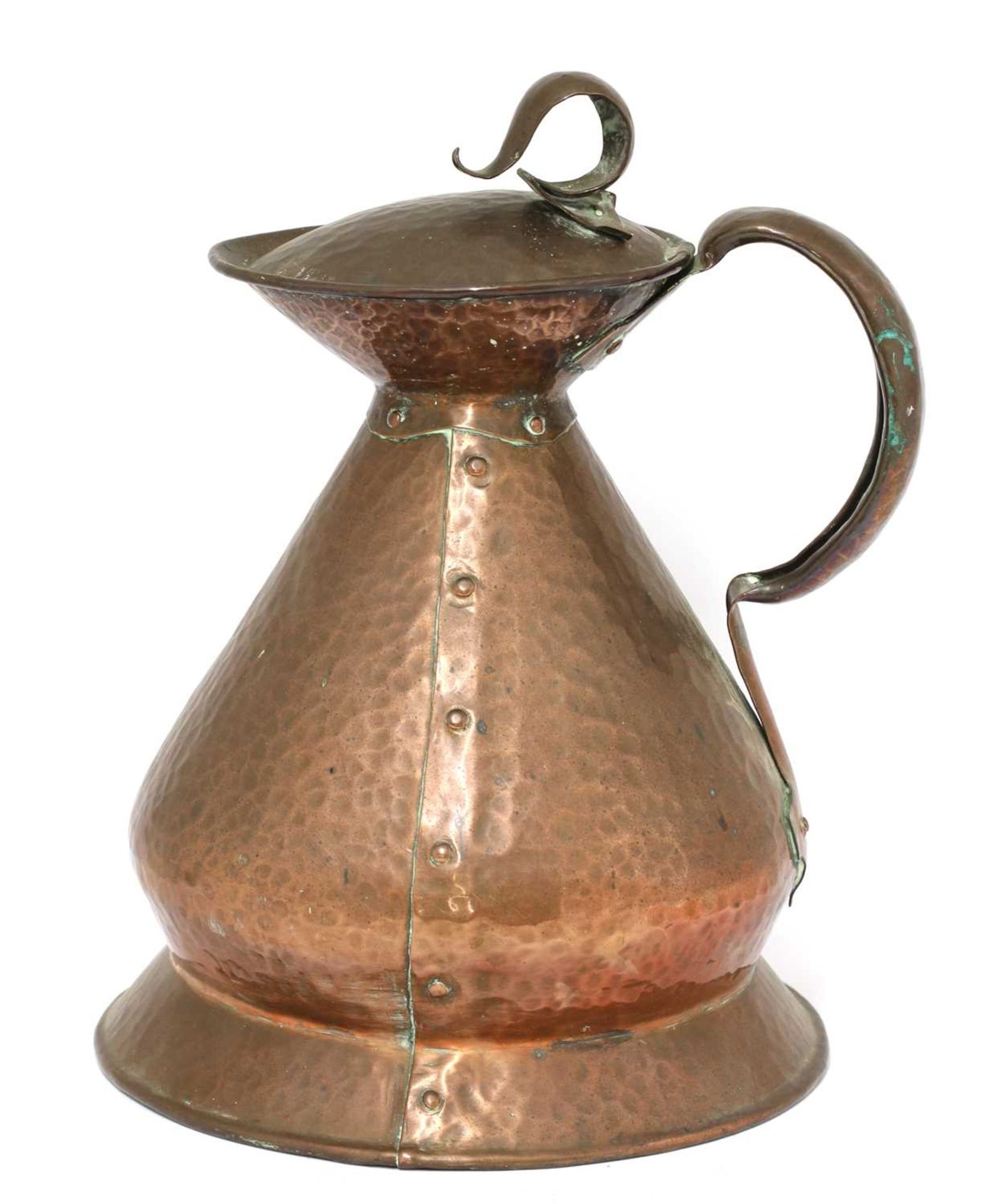 An Arts and Crafts hammered copper haystack measure and cover,