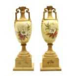 A pair of Vienna porcelain twin-handled urns on stands,