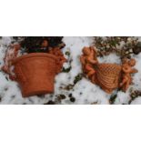 Two terracotta wall planters,
