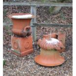 A pair of terracotta coloured stone urns of Campana form,