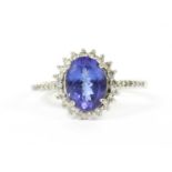 An 18ct white gold tanzanite and diamond halo cluster ring,