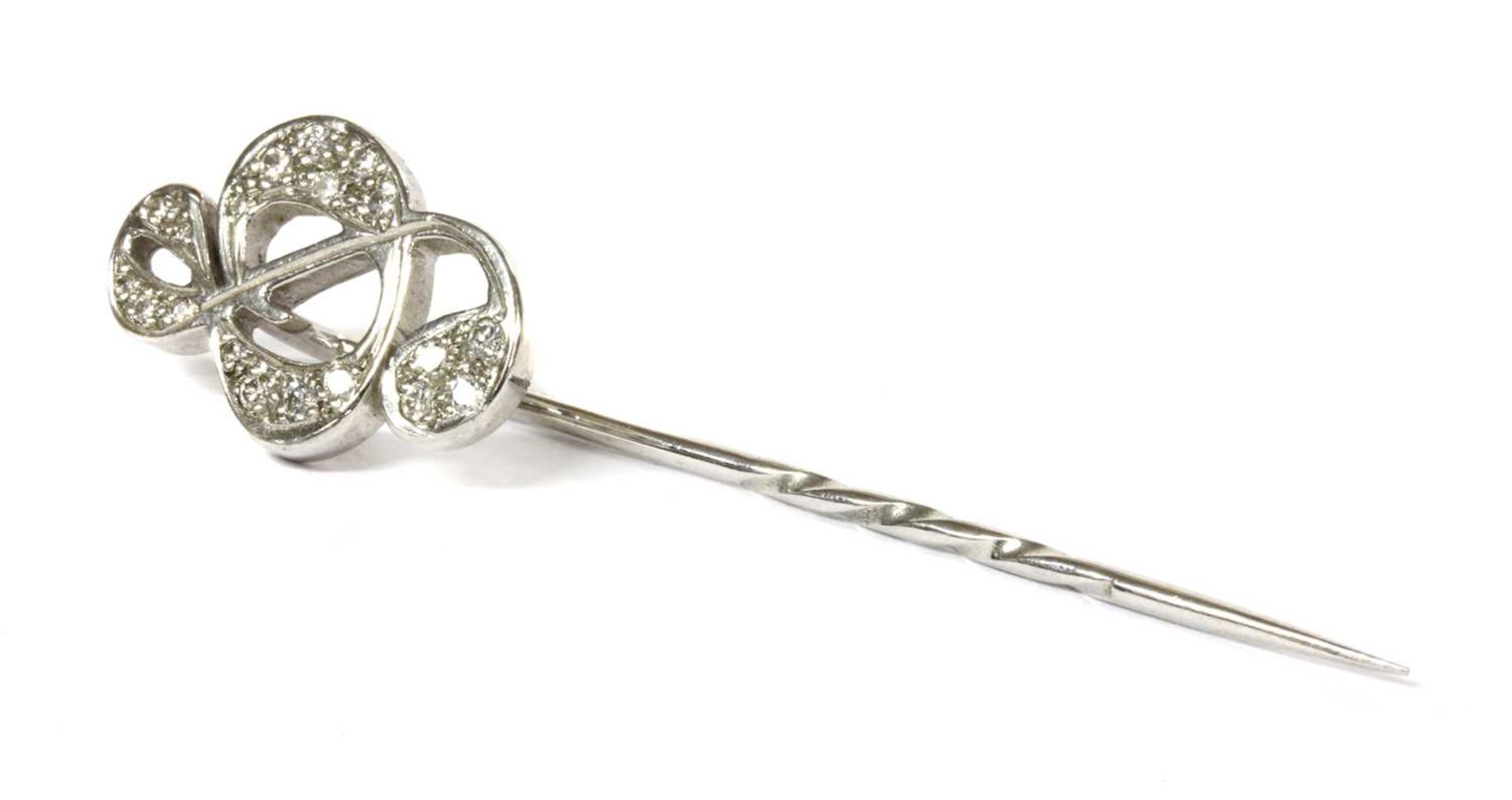 An 18ct white gold diamond set treble clef stick pin, by Theo Fennell,