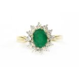 A gold emerald and diamond cluster ring,