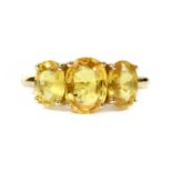 A gold three stone yellow sapphire ring,