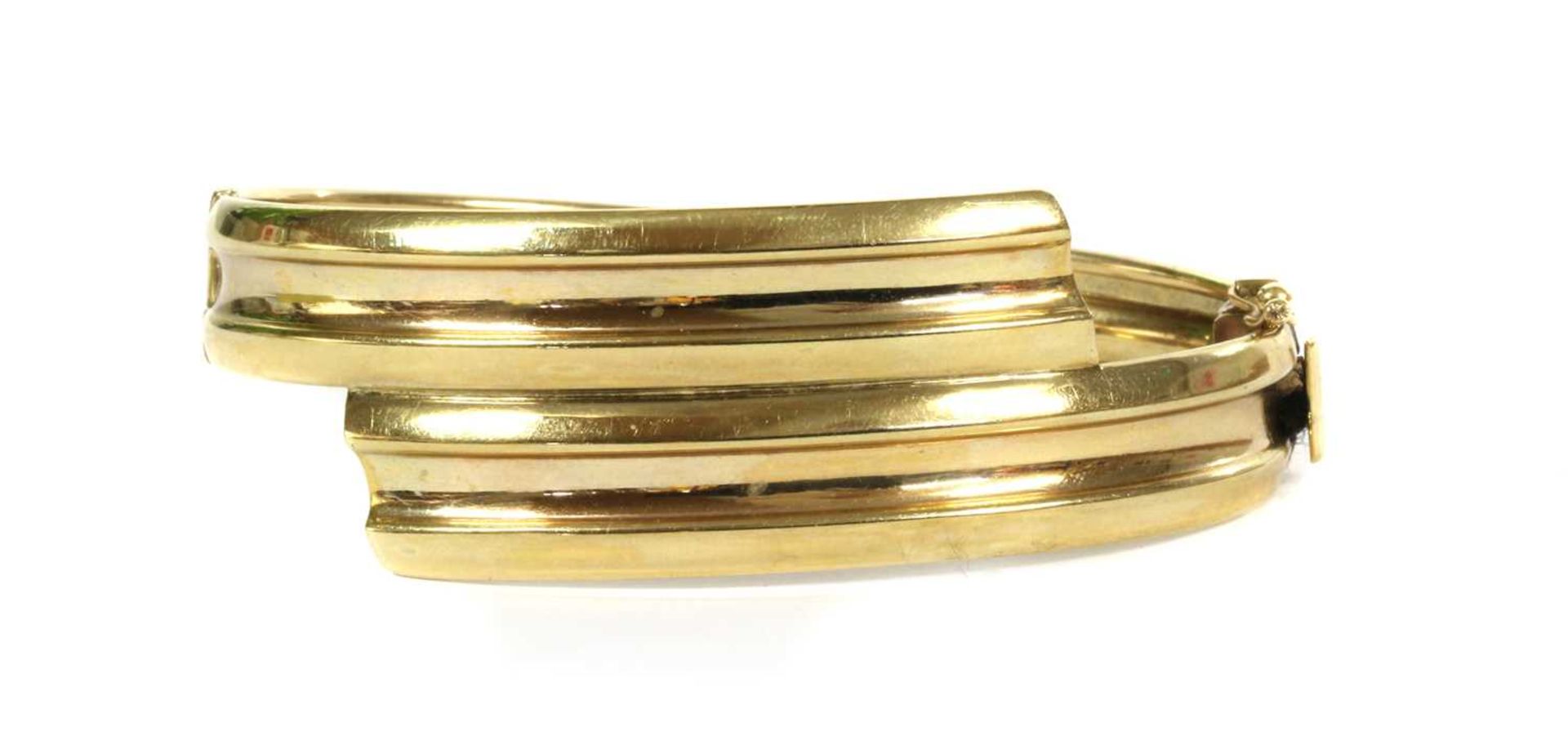 A 9ct gold oval hinged crossover bangle,