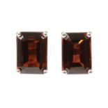 A pair of white gold single stone garnet stud earrings,