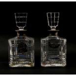 A pair of glass decanters with silver collars