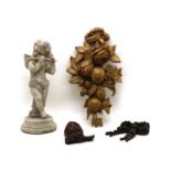 A carved and painted wooden figure of a cherub playing a flute,