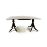 A George lll style mahogany twin pedestal dining table with one leaf,