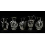 Five clear glass 'Mary Gregory' jugs,