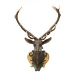 A carved and polychrome painted wooden stag head,