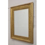 A modern carved giltwood wall mirror,
