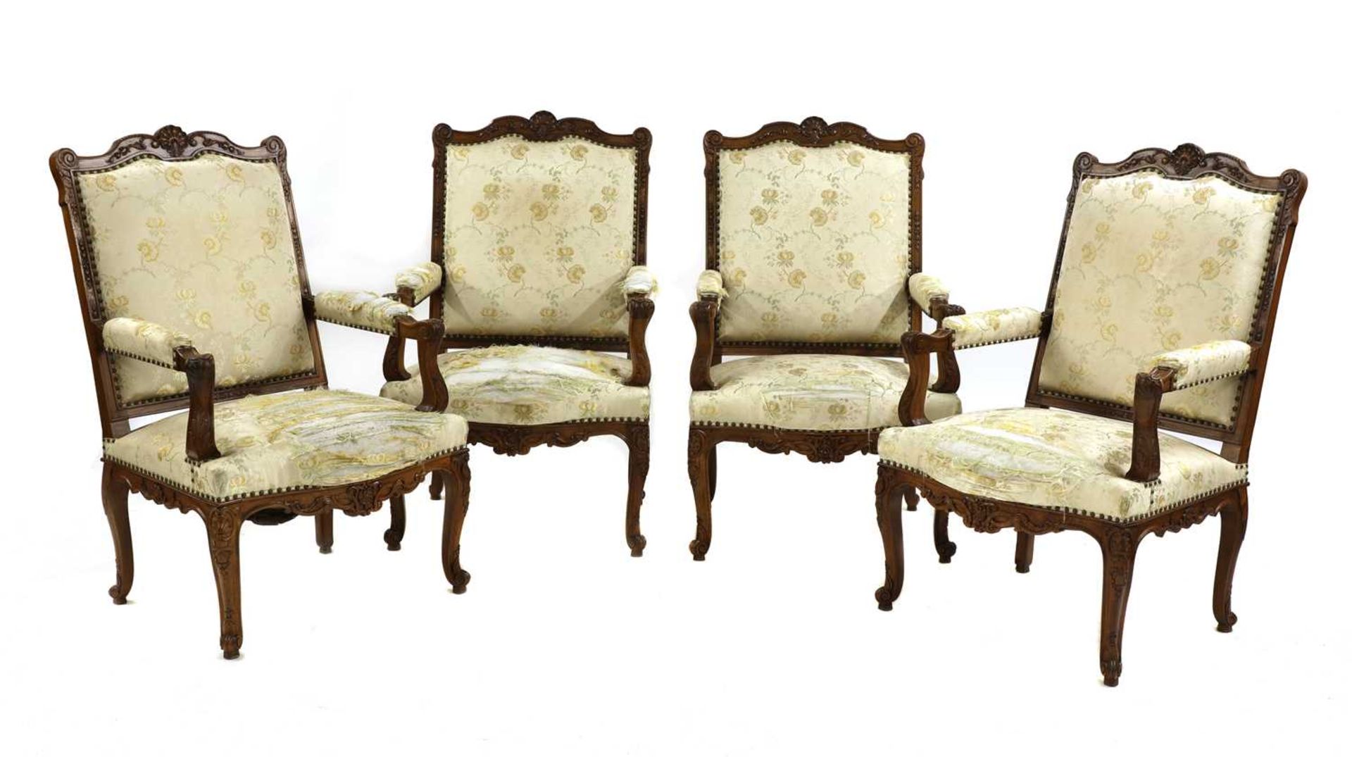 A set of four French Regency-style walnut elbow chairs,