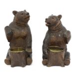 A near opposing pair of carved Black Forest bear ashtrays,