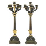 A pair of French Empire bronze and parcel gilt candelabrum,