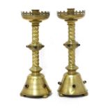 A pair of brass ecclesiastical candlesticks