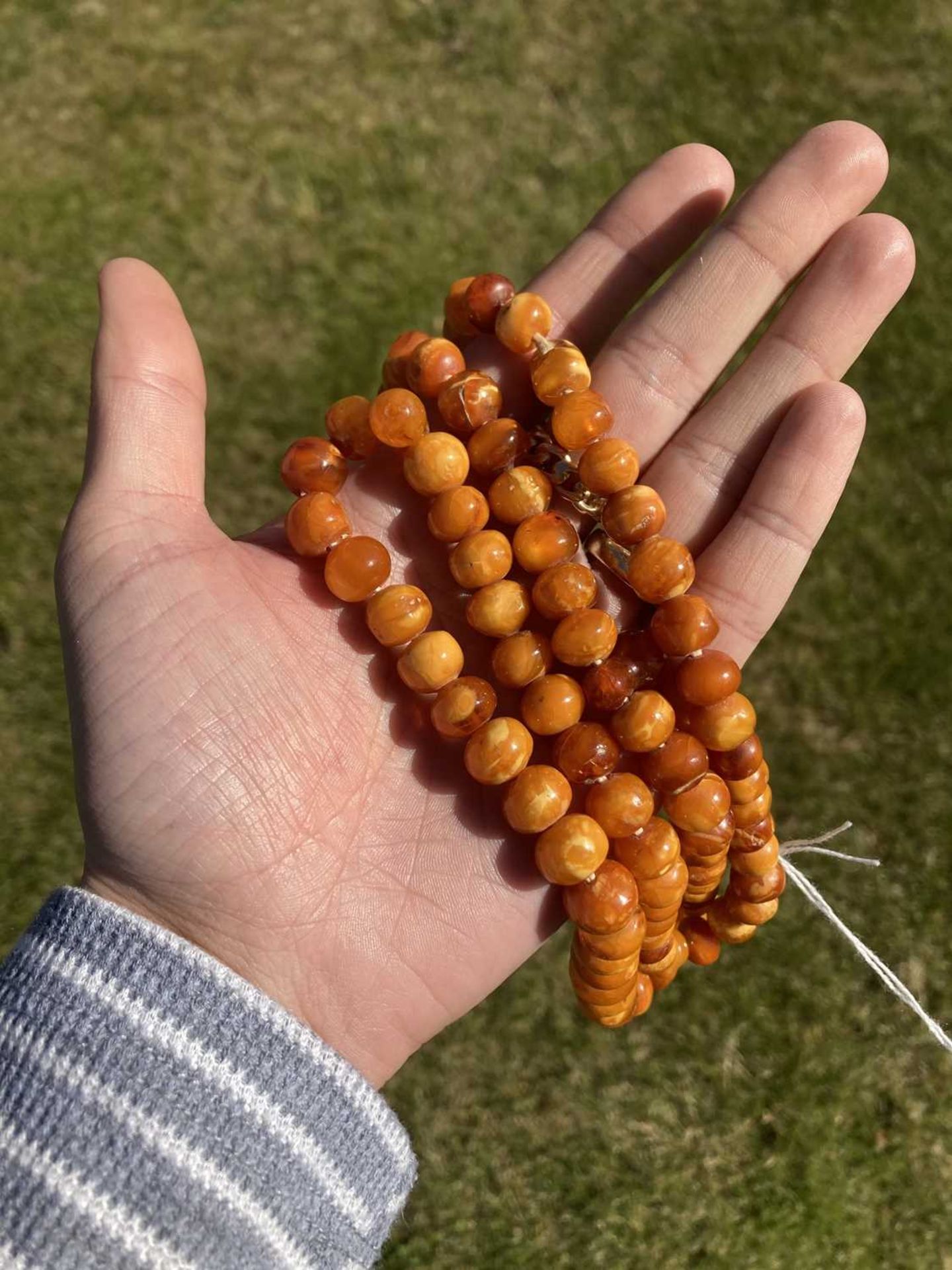 A single row slightly graduated butterscotch amber prayer bead necklace, - Image 14 of 15