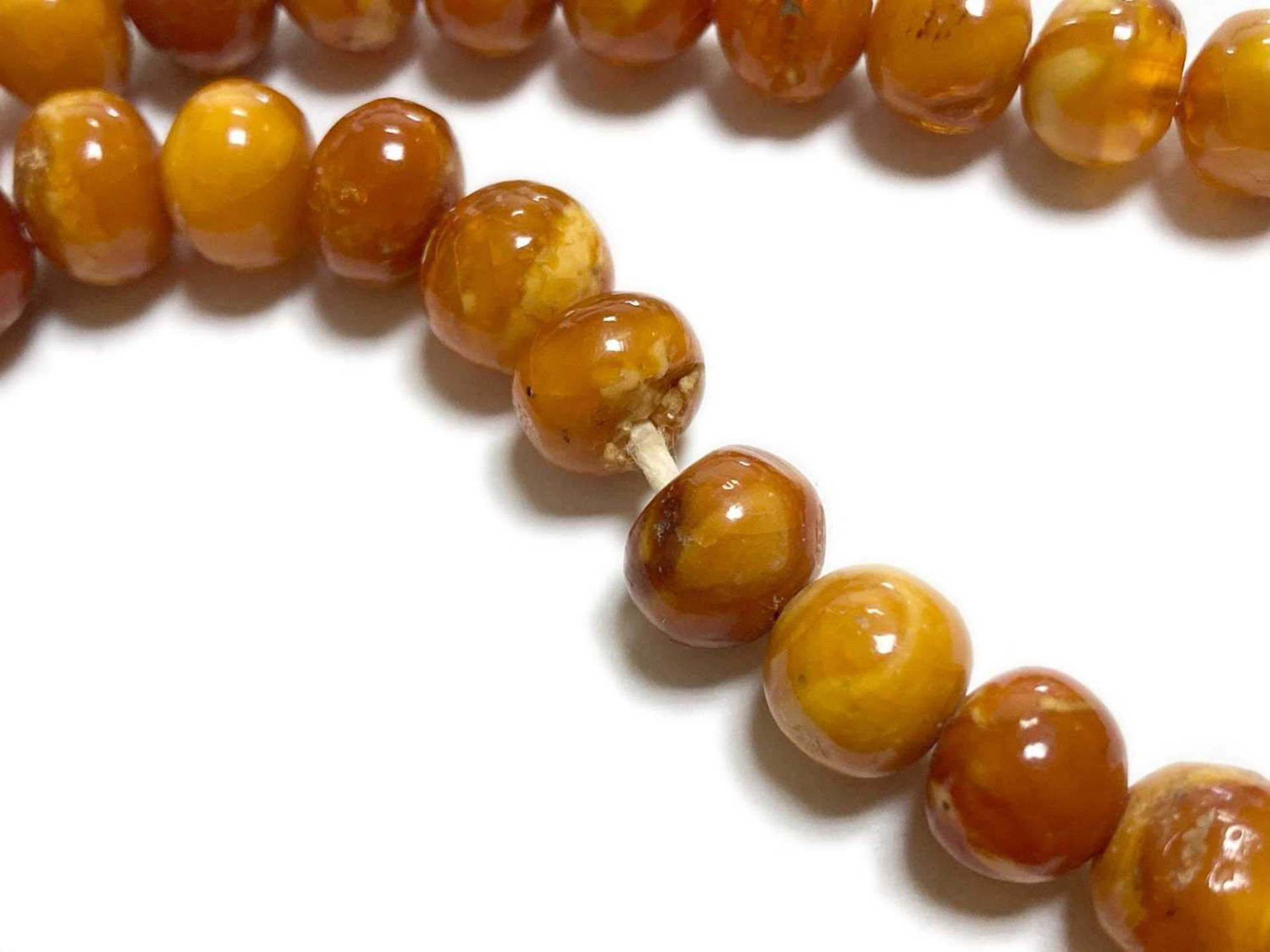 A single row slightly graduated butterscotch amber prayer bead necklace, - Image 8 of 15