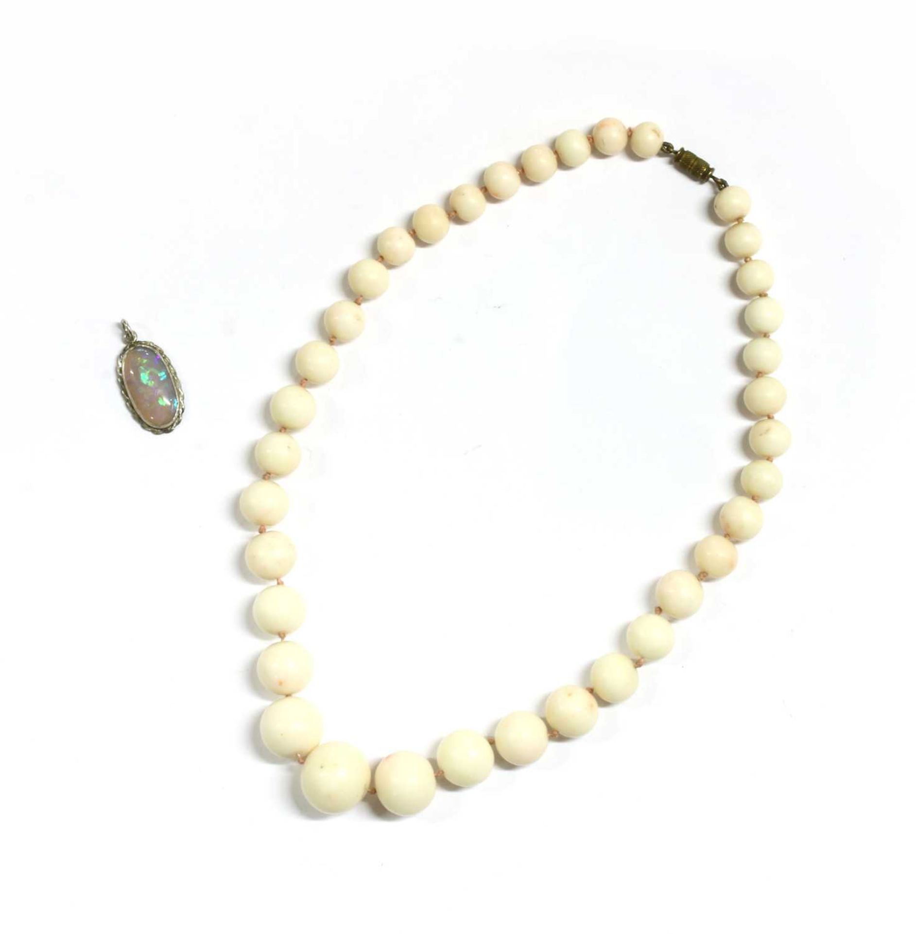 A single row graduated carved white/pale pink coral necklace,