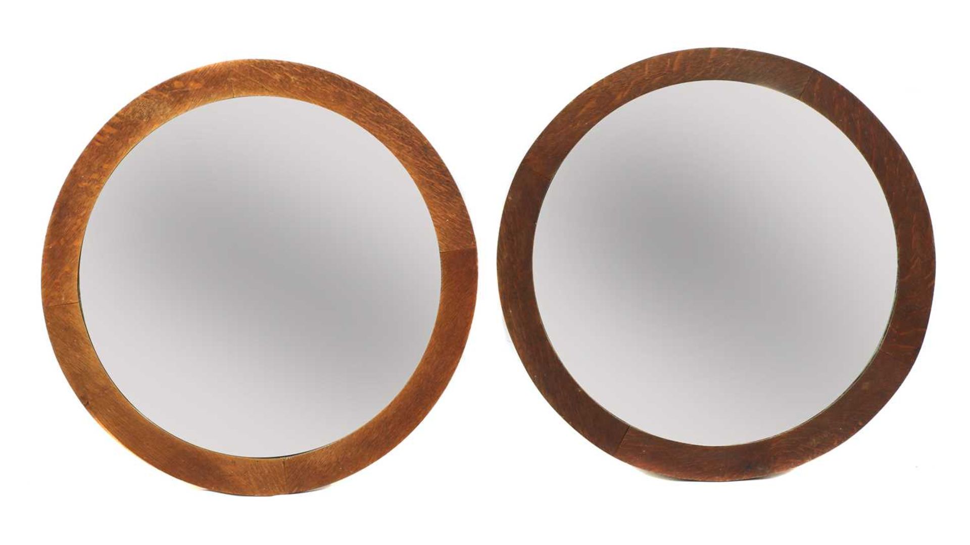 A pair of Arts and Crafts circular oak wall mirrors,