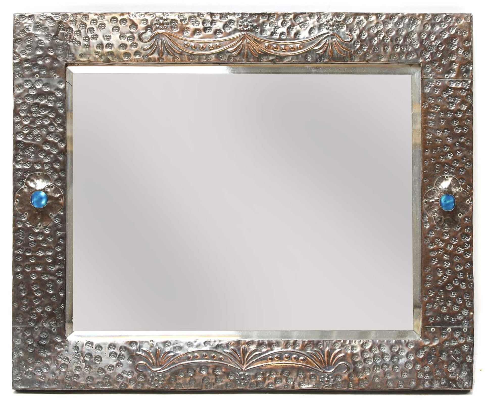 An Arts and Crafts embossed copper mirror,