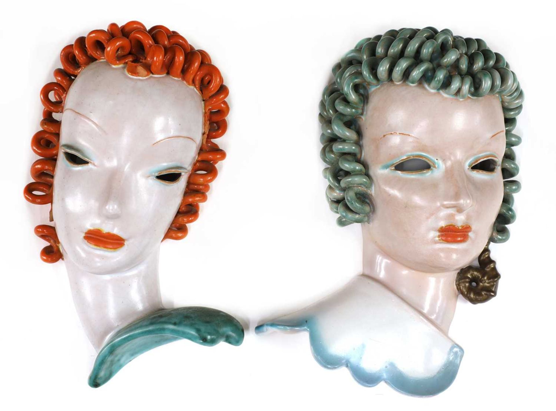 Two Goldscheider pierced eye pottery wall masks,