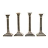 Two pairs of similar Victorian silver pillar candlesticks,