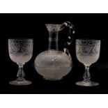 An etched glass carafe and two glasses